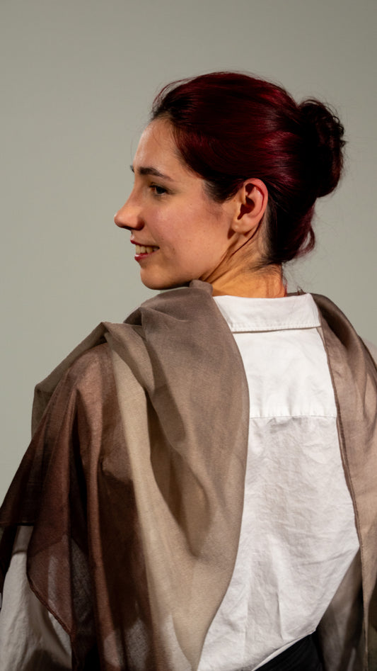female model shot from the back: wearing wool silk shawl with earthly tones of light and dark brown and black