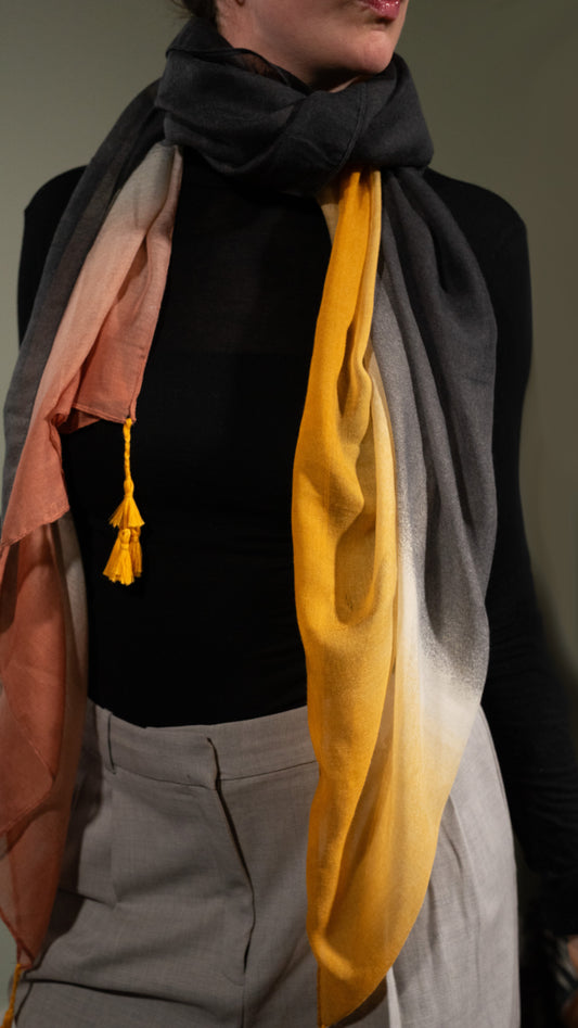 model wearing wool silk shawl with light pink/orange, yellow, white, and black. front