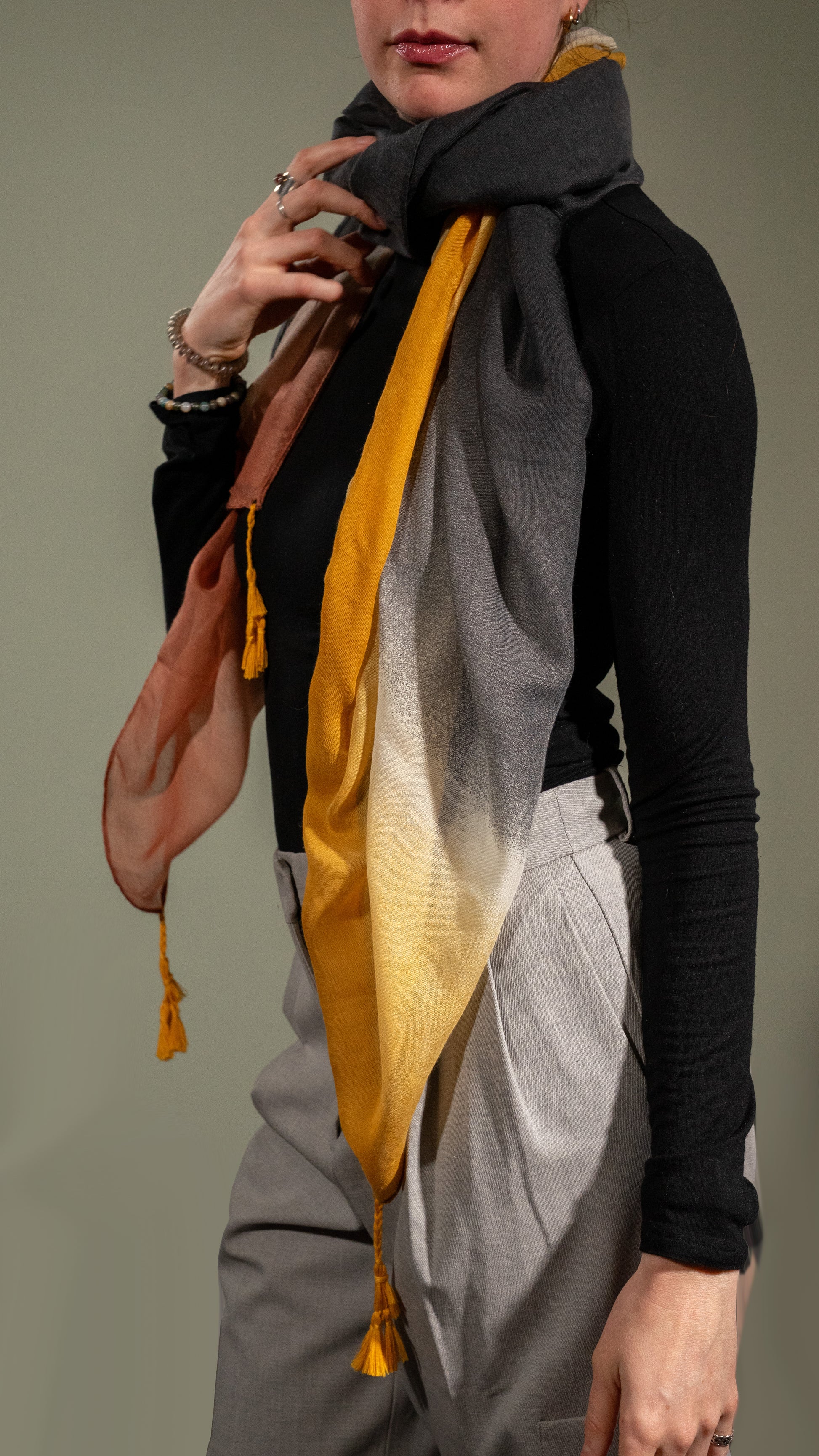 model wearing wool silk shawl with light pink/orange, yellow, white, and black. side