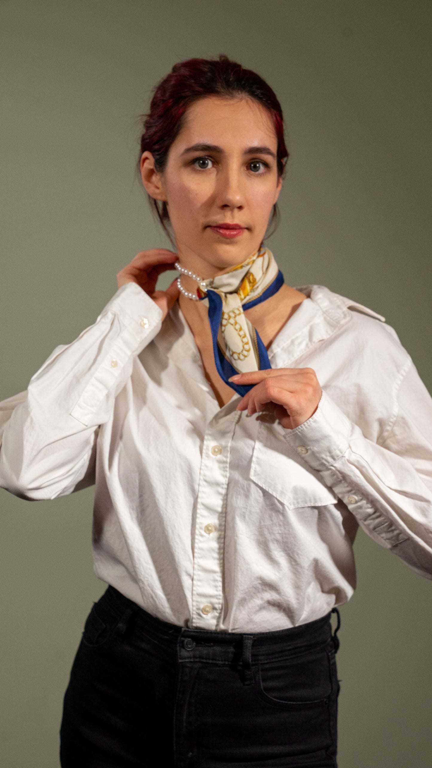 a model putting on an elegant square handwoven 100% pure silk scarf with beige, gold, and blue colours
