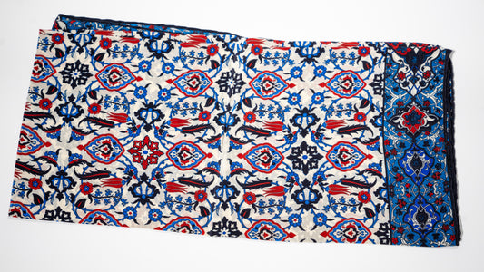 vegan silk scarf with blue, red, black and white tones, featuring intricate patterns. Folded