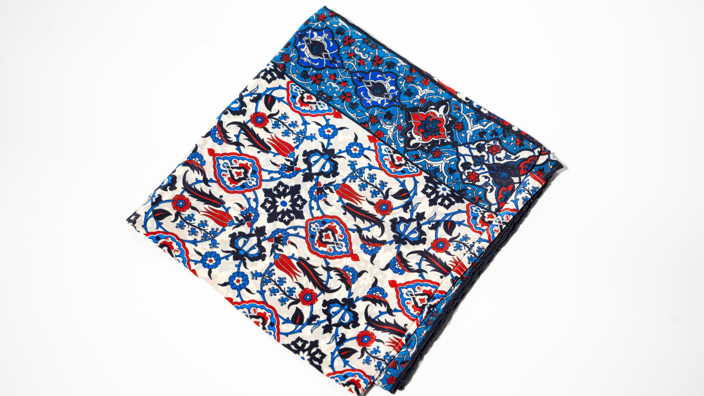 vegan silk scarf with blue, red, black and white tones, featuring intricate patterns. Folded
