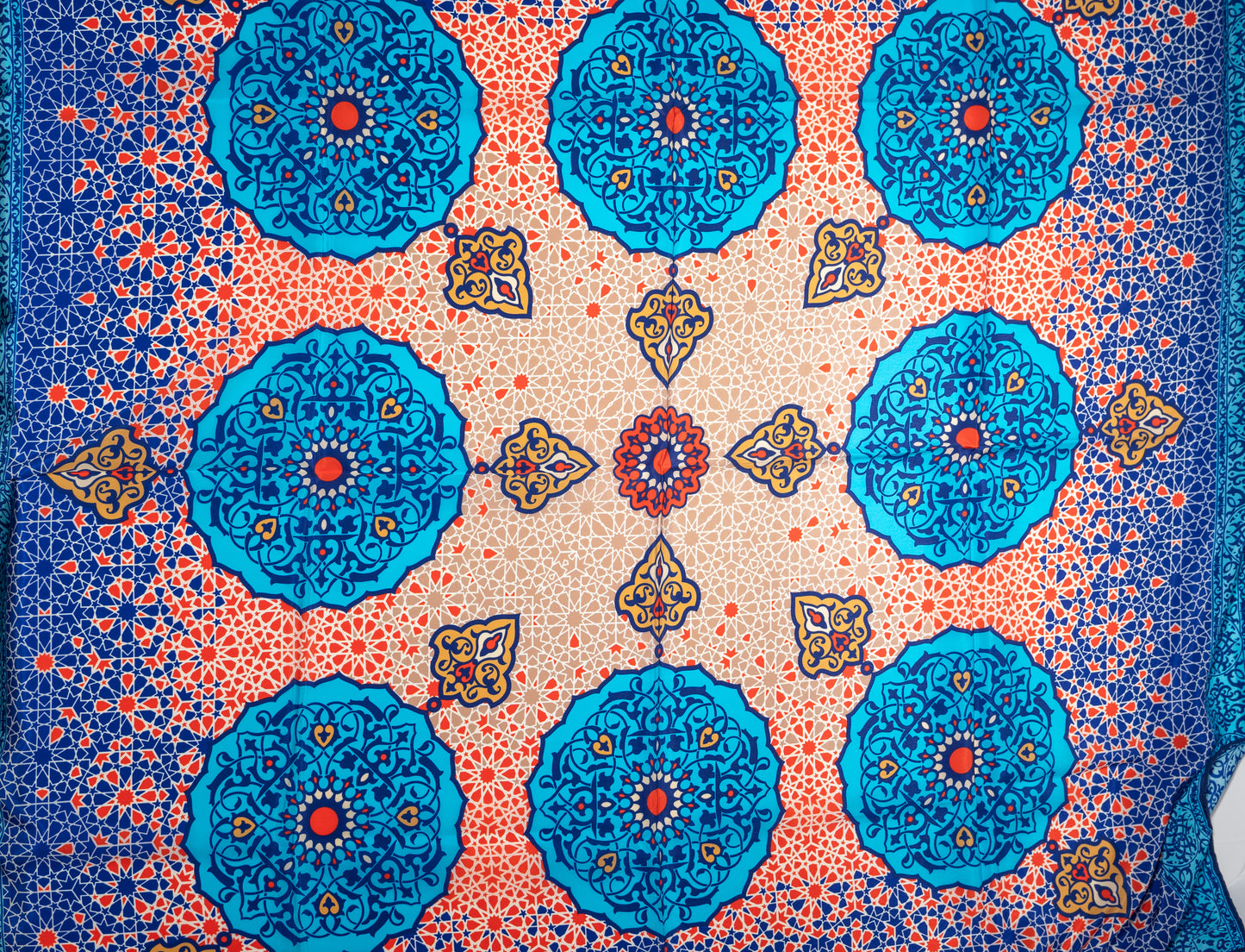 vegan silk scarf with light and dark blue, yellow, orange, and white tones, featuring intricate geometric designs. zoom on designs