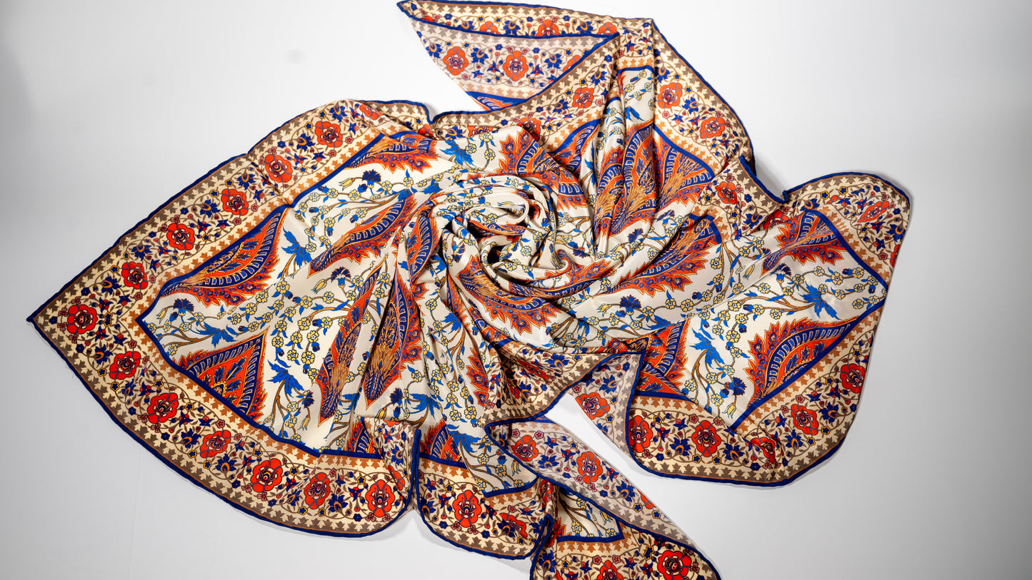vegan silk scarf with orange, beige, blue, and yellow tones, featuring intricate floral designs. scrambled