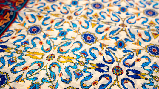 vegan silk scarf with yellow, red, beige, and blue tones, featuring intricate designs.  close-up