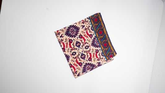 vegan silk scarf with yellow, red, beige, and purple tones. folded.