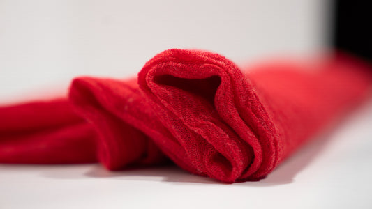 close-up of a soft, deep red, handwoven wool silk scarf, gently folded