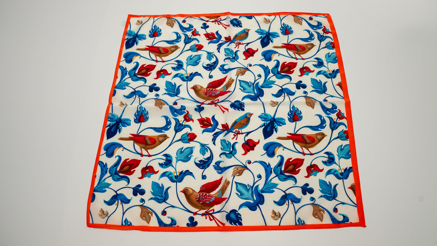 a colourful square vegan silk bandana including blue, white, red, and brown, featuring birds.