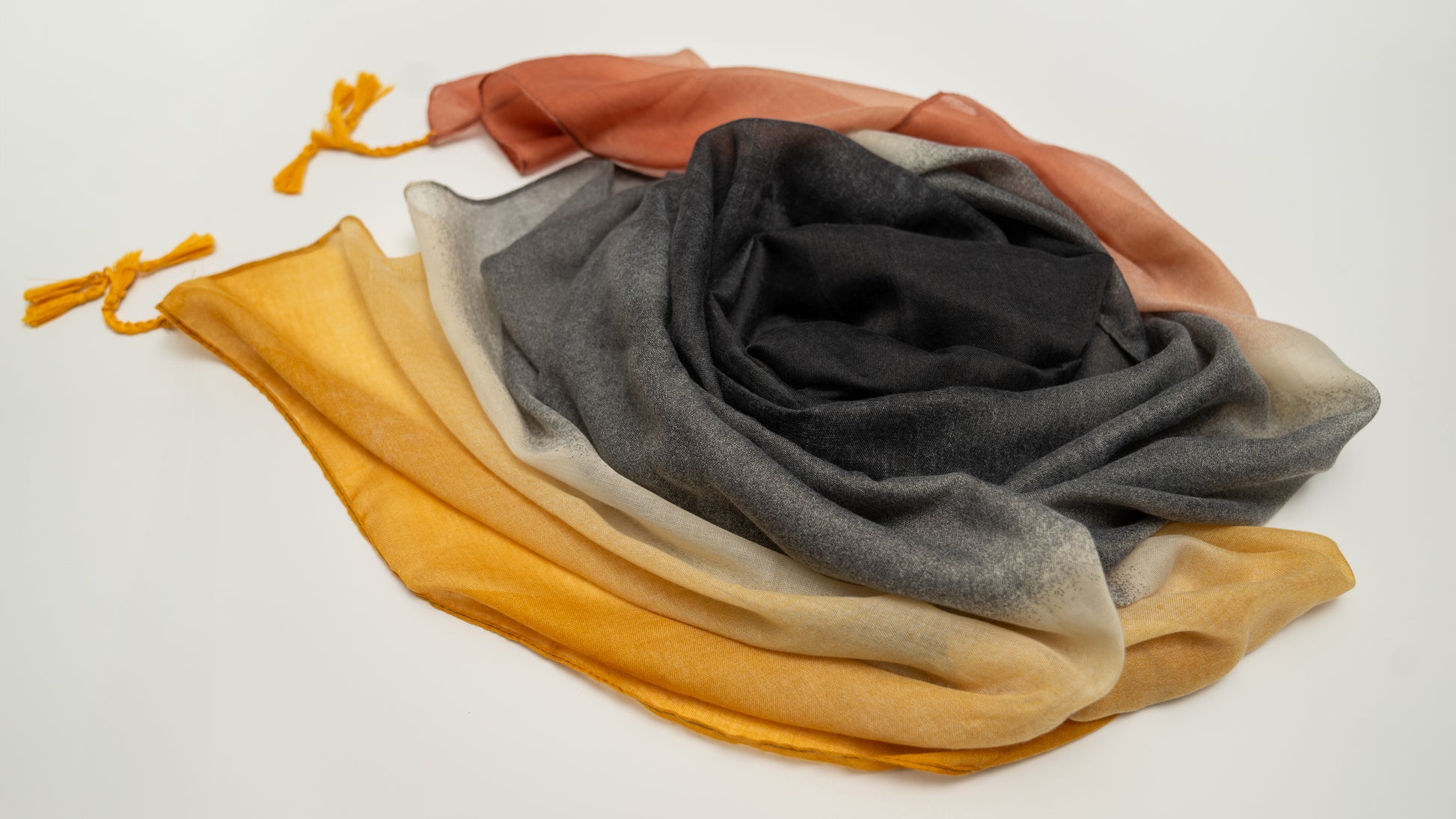 wool silk shawl with light pink/orange, yellow, white, and black. close-up