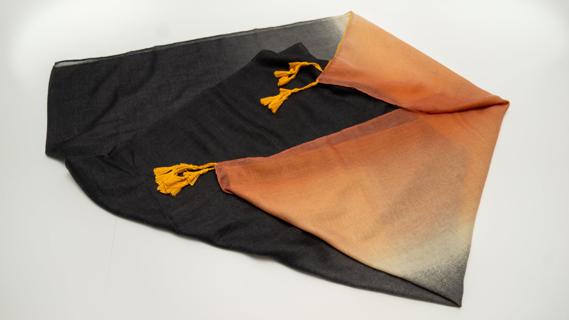 wool silk shawl with light pink/orange, yellow, white, and black. folded.