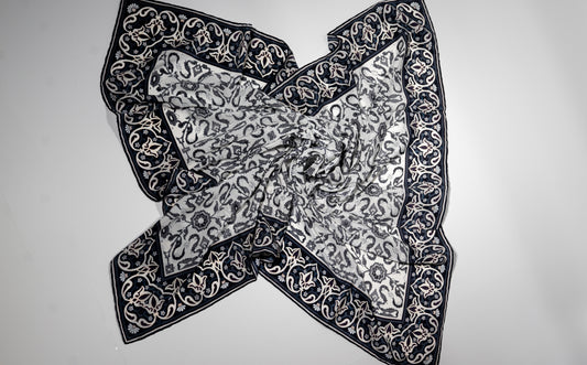vegan silk scarf with white and black tones with intricate designs.
