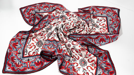 vegan silk scarf with white, grey, and  red tones with floral designs. rolled