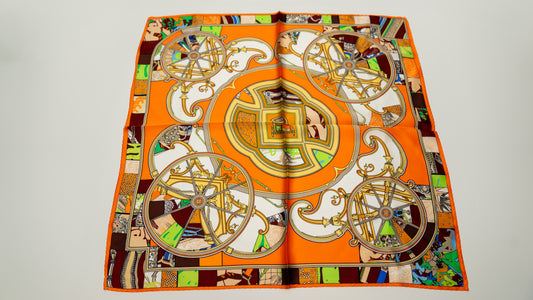 a colourful square 100% pure silk scarf, featuring circular designs with a predominantly orange colour