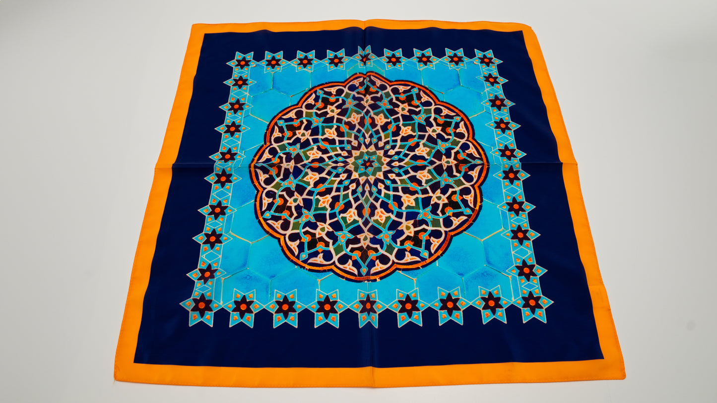 a square vegan silk bandana with geometric designs, featuring light and dark blue, orange and white colours