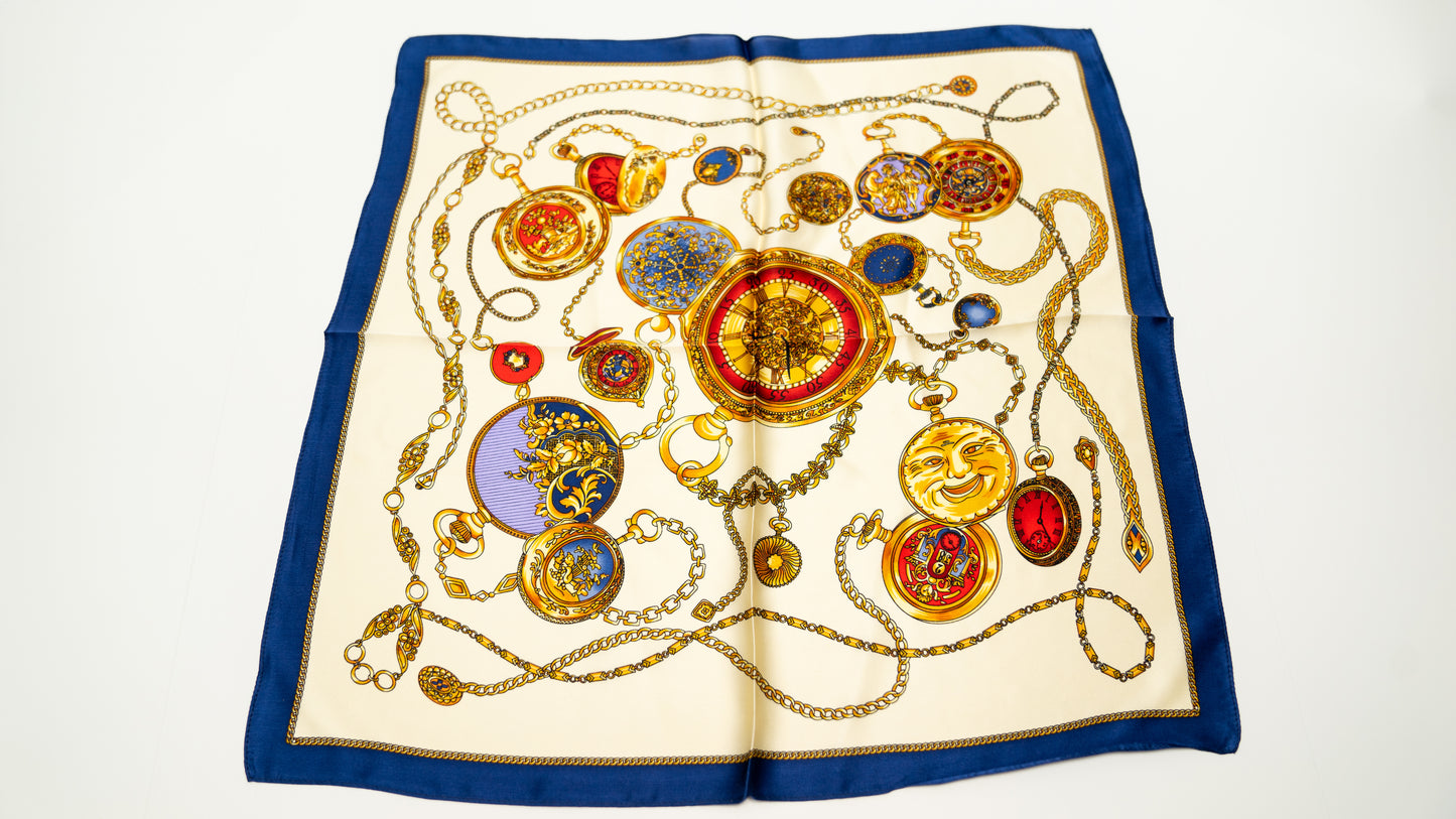 an elegant square handwoven 100% pure silk scarf with beige, gold, and blue colours, front shot.