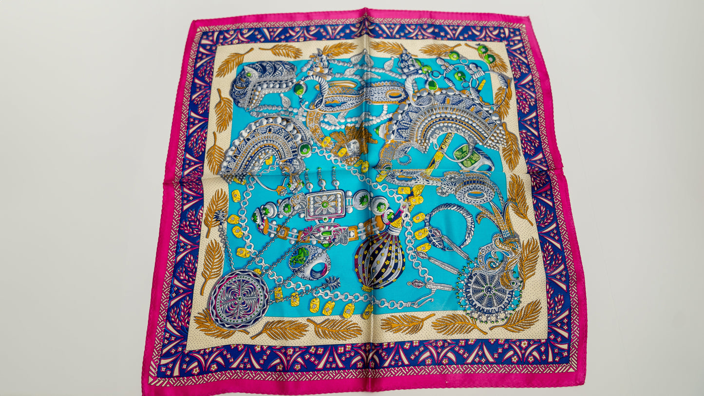 a square handwoven 100% pure silk scarf with vibrant blue, purple, and pink colours and intricate designs