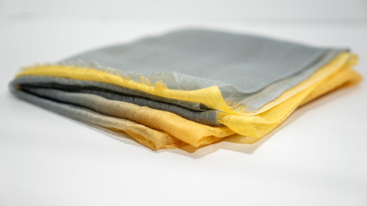 handwoven wool silk scarf, featuring light grey and vibrant yellow tones. Folded gently