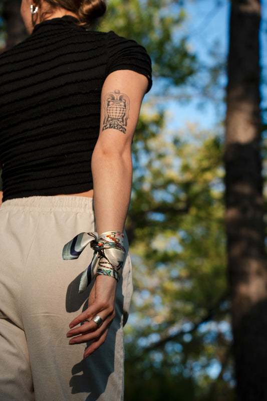 female model wearing a pure silk square scarf, wrapped on the wrist.