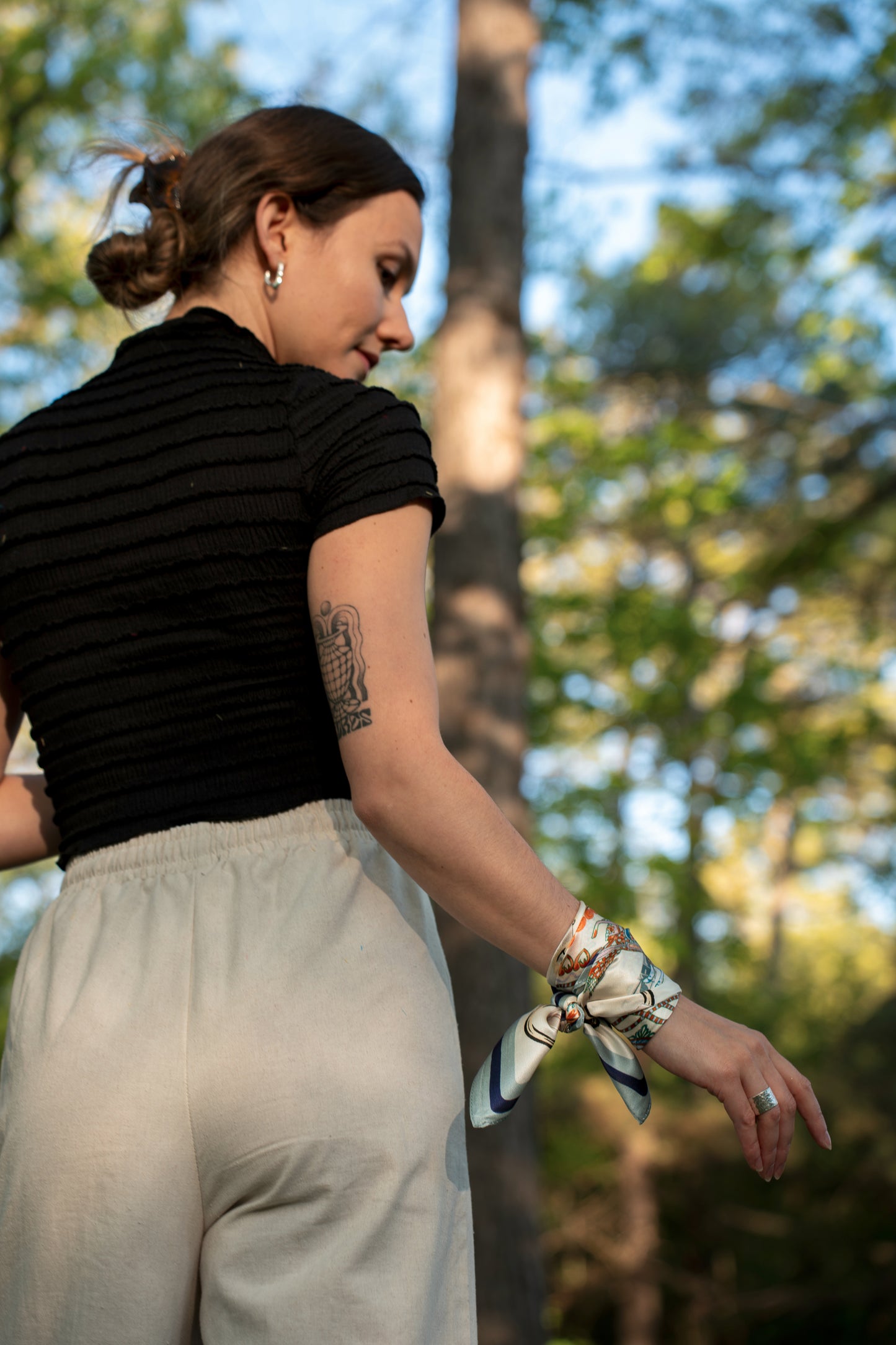 female model wearing a pure silk square scarf, wrapped on the wrist.