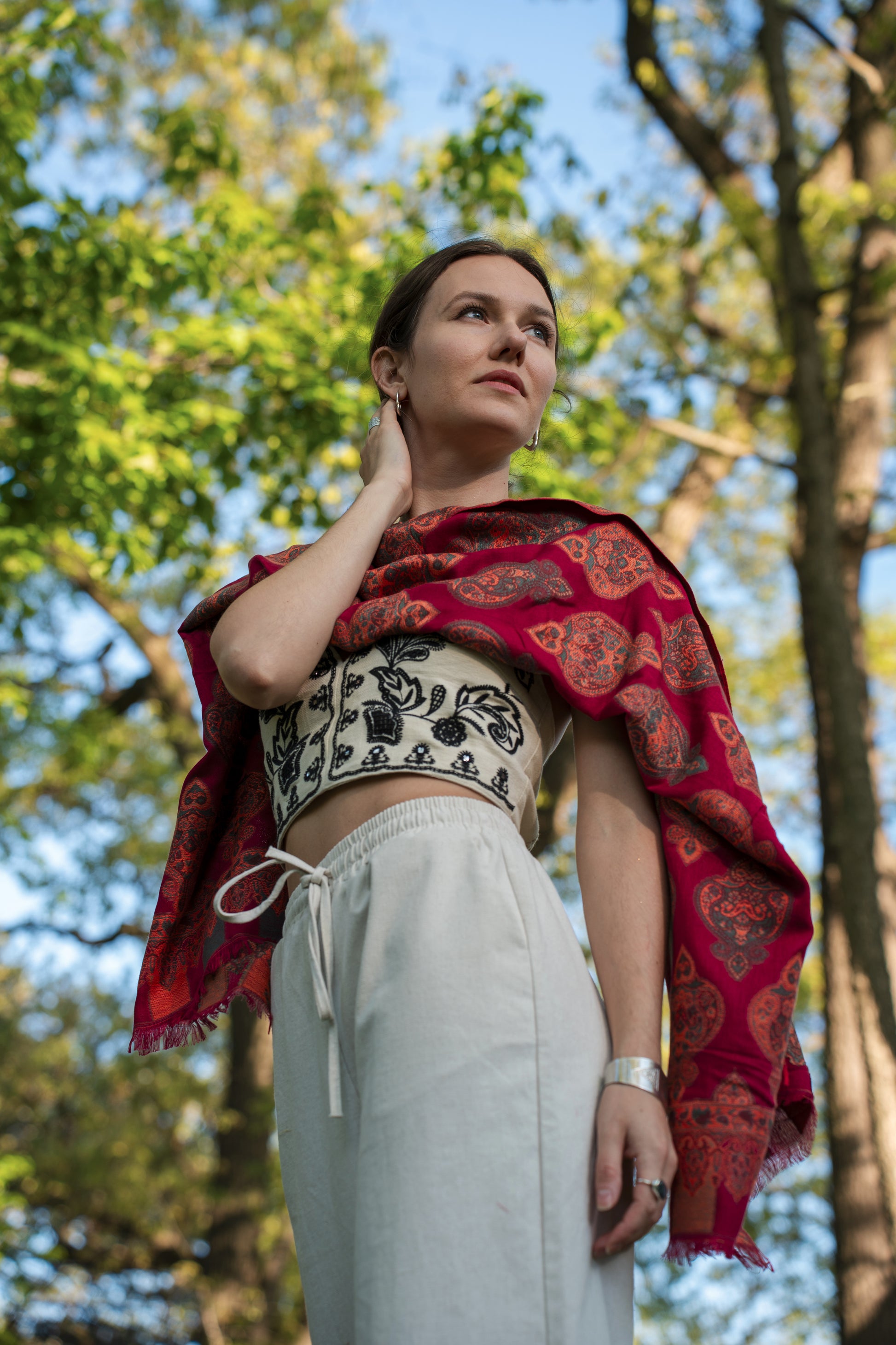 female model wearing a red cotton and wool turkish shawl, red fields.