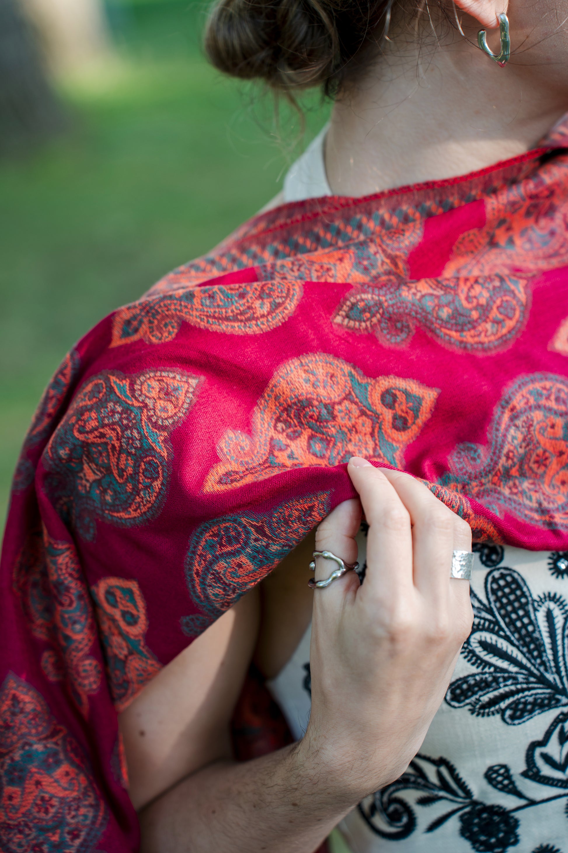 female model wearing a red cotton and wool turkish shawl, red fields.
