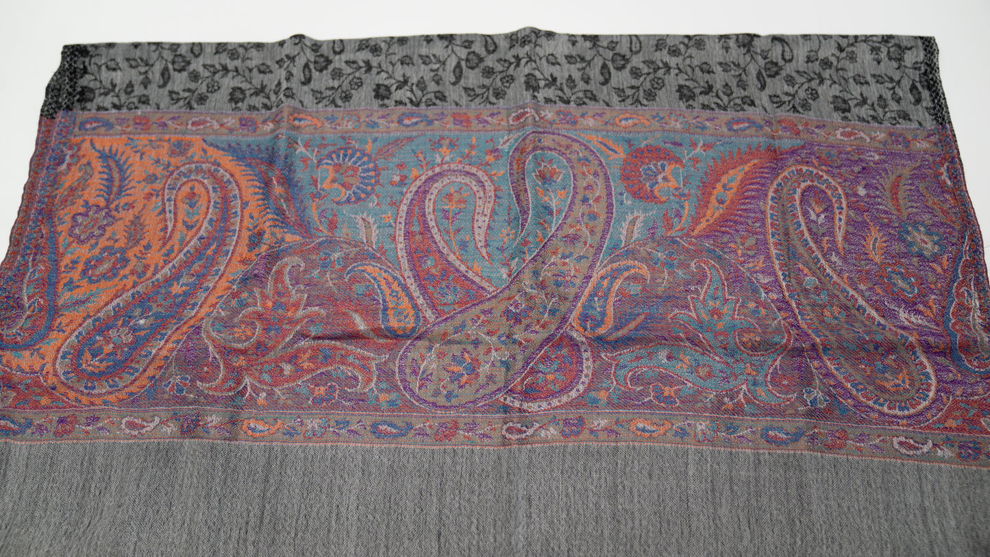turkish cashmere shawl, black and grey with coloured accents, folded.
