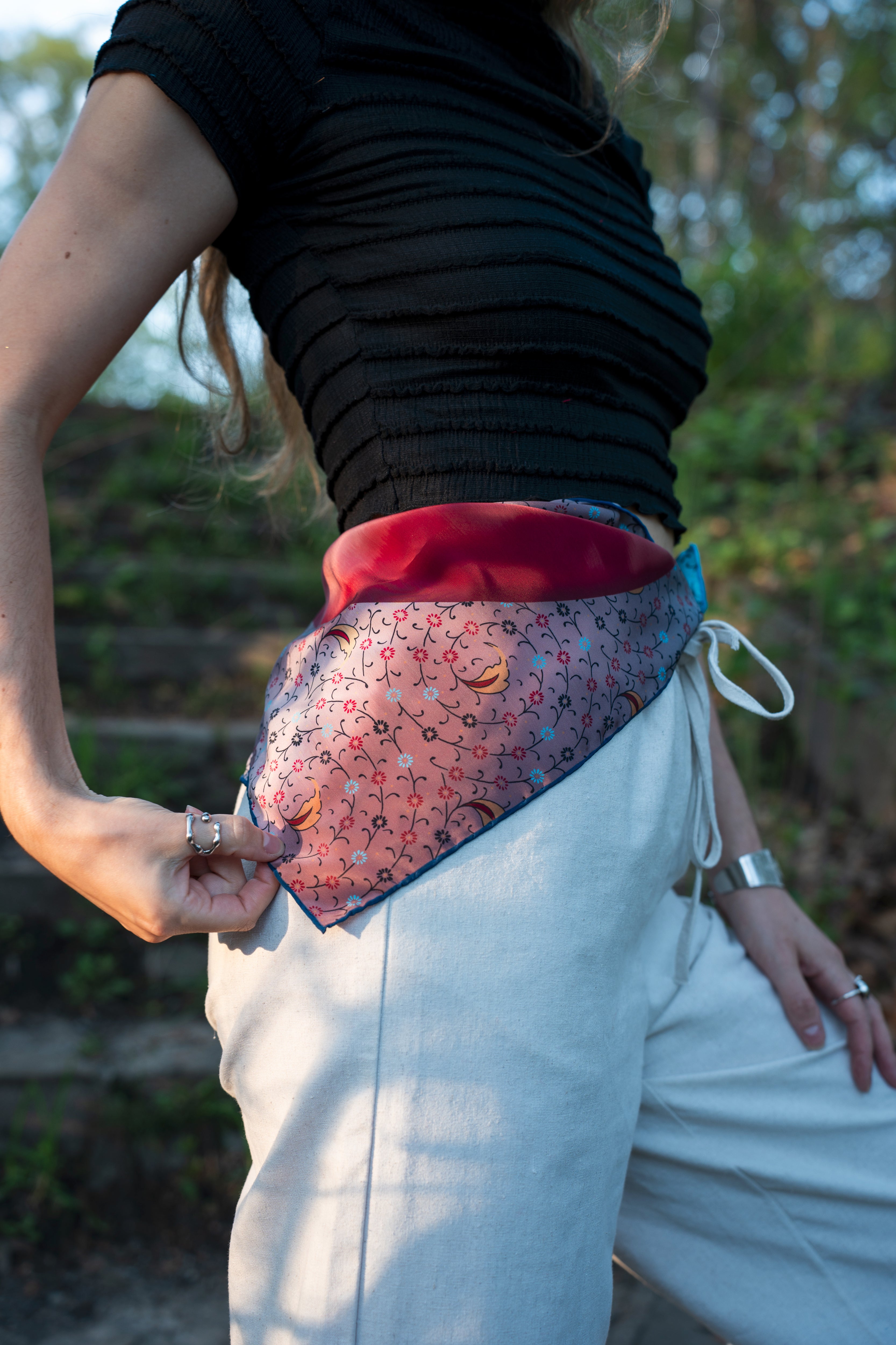 female model wearing a square large vegan silk bandana, wrapped around the beltline. 