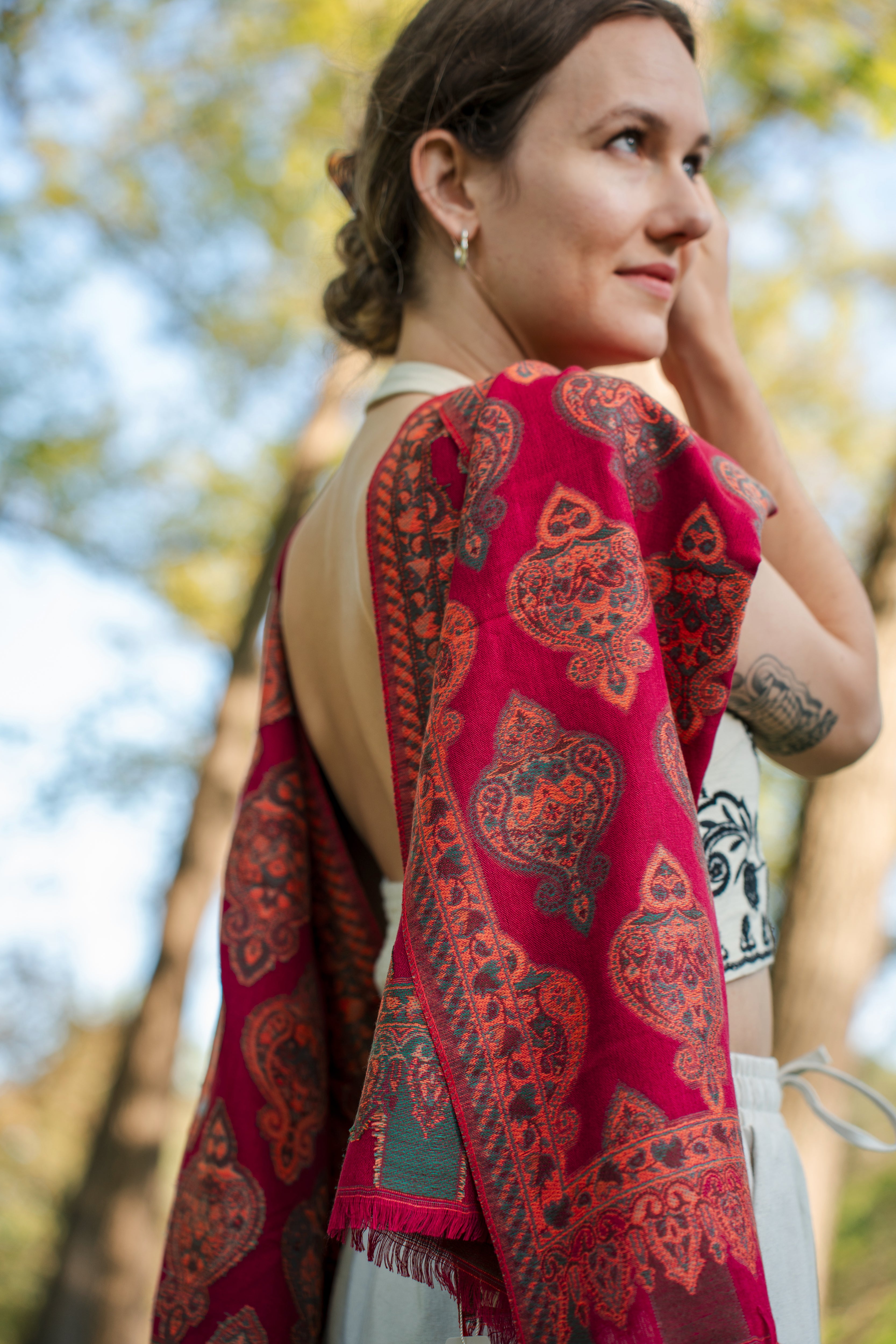 female model wearing a red cotton and wool turkish shawl, red fields.